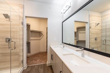 a bathroom with a large mirror and a sink and a shower